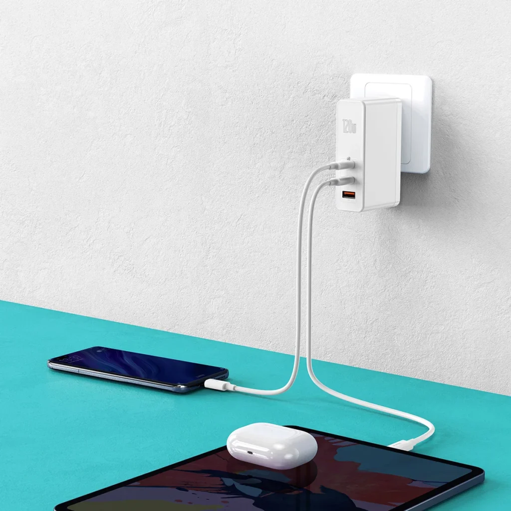Close-up of a compact Baseus GaN charger plugged into a wall outlet, showcasing its small form factor and efficient design