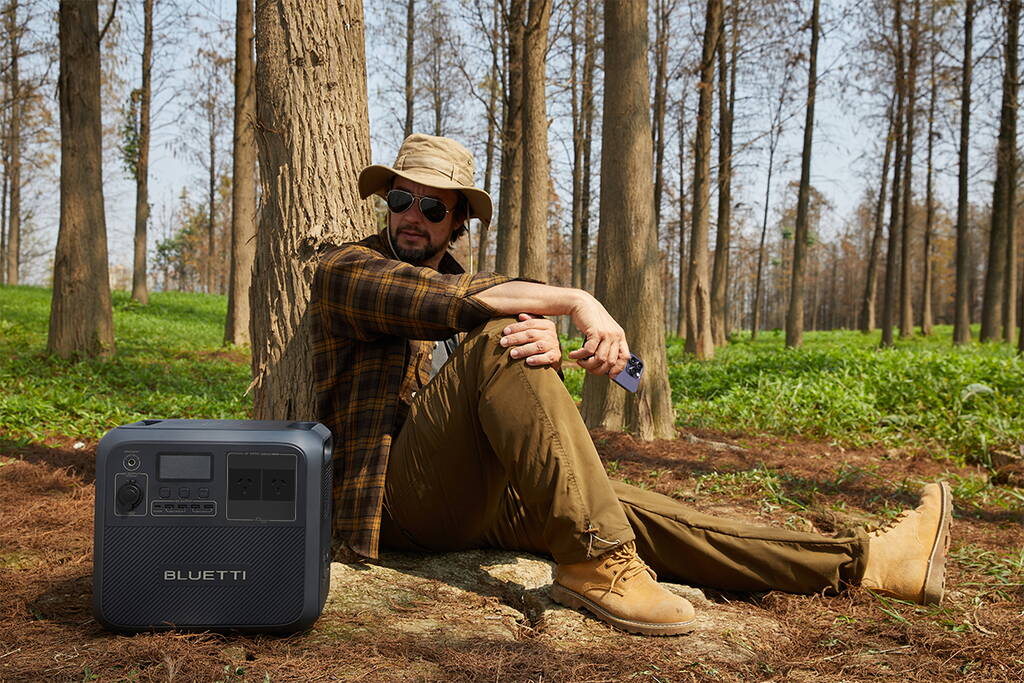 Bluetti Review 2026: Is This Power Station Brand Worth It? Bluetti AC180 portable power station being used to power camping equipment in a scenic outdoor setting