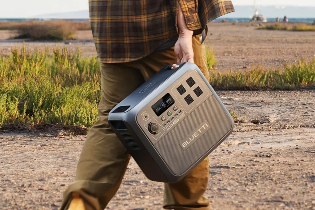 Bluetti Review 2026: Is This Power Station Brand Worth It? Bluetti AC180 portable power station being used to power camping equipment in a scenic outdoor setting