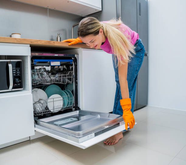 Interior of an LG dishwasher with QuadWash technology, showcasing organized racks and sparkling dishes."