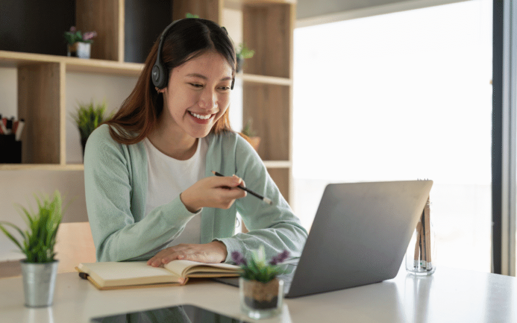 A happy person learning online with Udemy courses on a laptop.