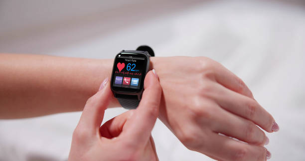 "Close-up of a wrist wearing a sleek, modern smartwatch showing health data such as heart rate and oxygen levels on the screen