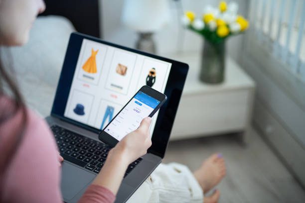 A person smiling while using a laptop for online shopping, with digital coupon icons and savings symbols floating around, representing smart shopping and maximizing discounts."