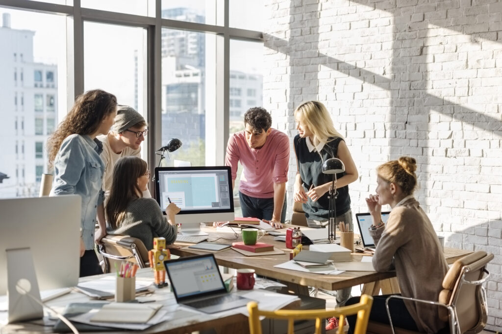 A diverse group of people collaborating in a modern office environment, perhaps with technology elements subtly present