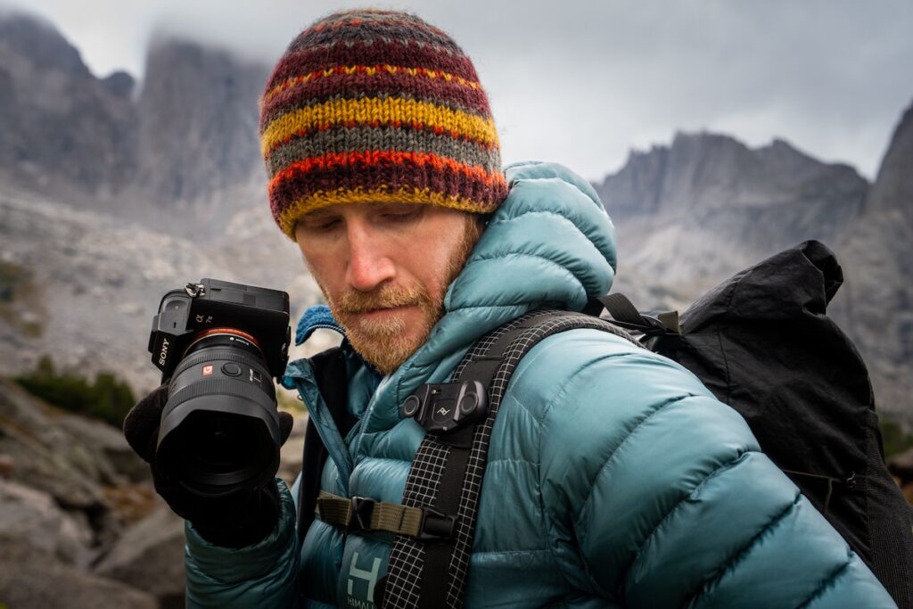 Hiker with an action camera capturing a mountain view