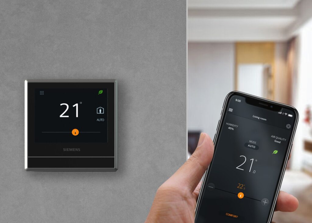 A close-up of a Nest Learning Thermostat on a light gray wall, showing the current temperature.