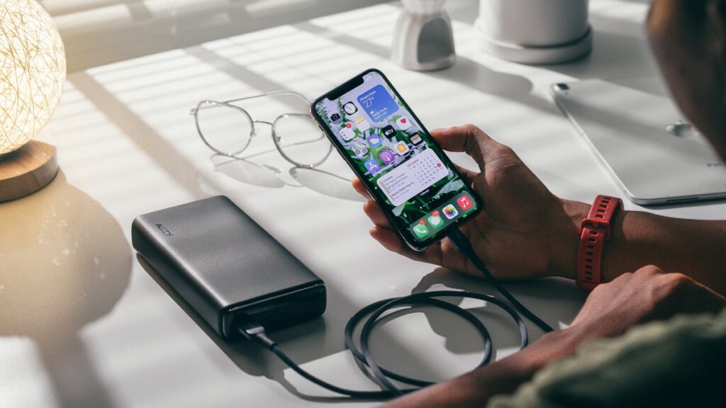 The Best Tech Gifts Under $50 for Everyone on Your List A compact portable power bank connected to and charging a smartphone.